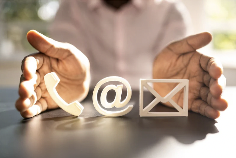 manos separadas y entre ellas el símbolo de um telefono, un @ y una carta